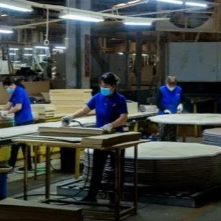 Công nhân chà nhám mặt bàn gỗ trong xưởng nội thất Biên Hòa