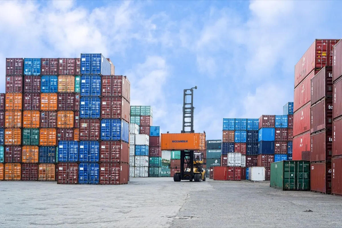 Xe nâng container làm hàng giữa các chồng container tại bãi cảng
