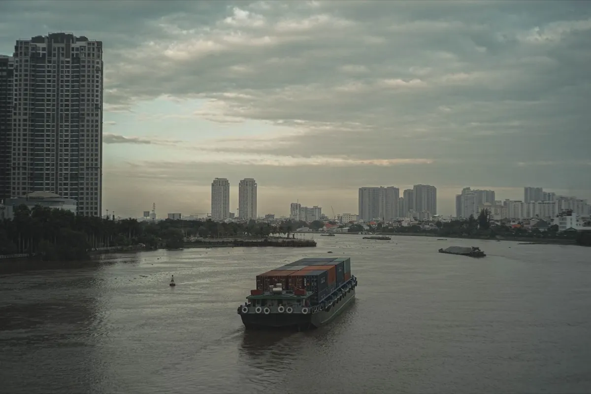 Sà lan chở container chạy trên sông Sài Gòn giữa khu đô thị