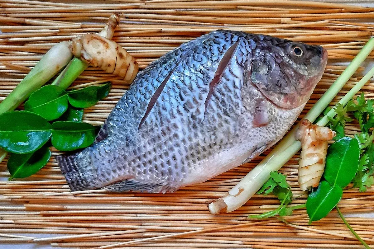 Cá rô phi nguyên con đặt trên nền mành tre cùng sả