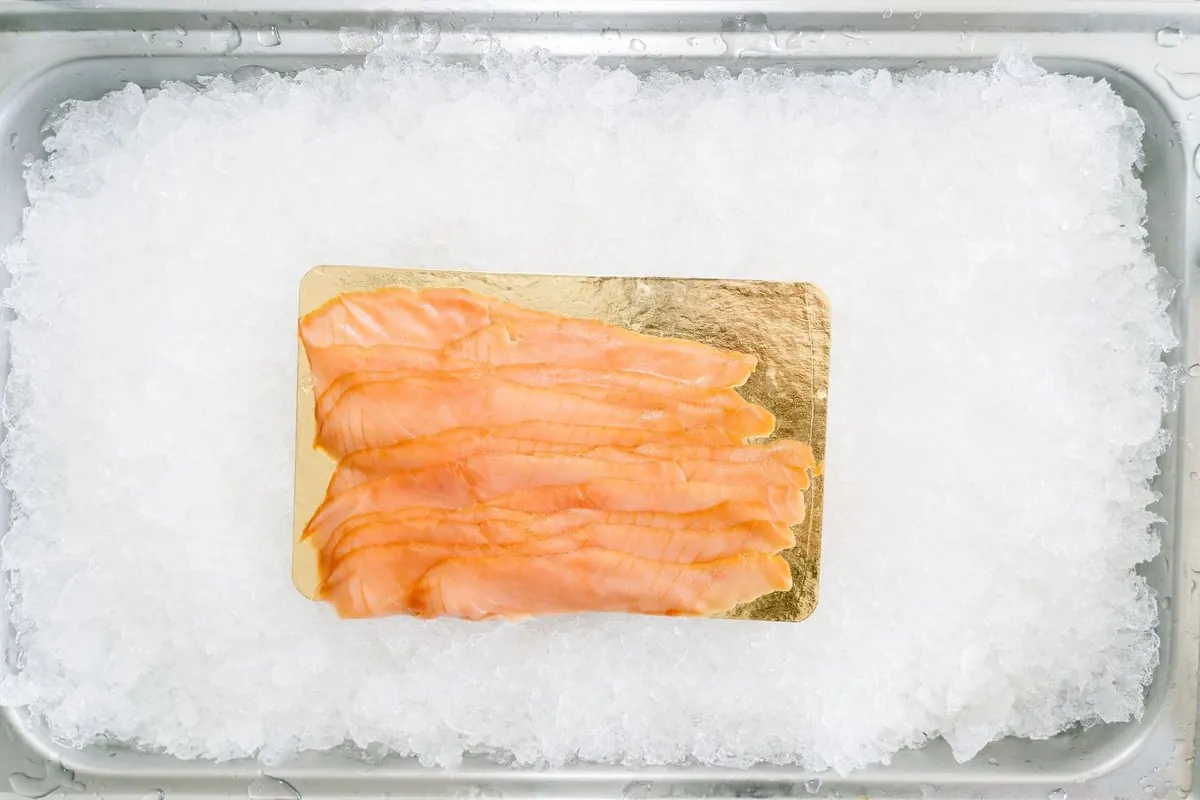 Slices of smoked salmon on a tray of ice