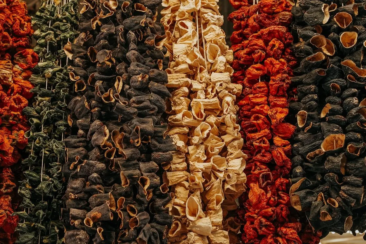 Strings of dried vegetables hanging in rows at a market