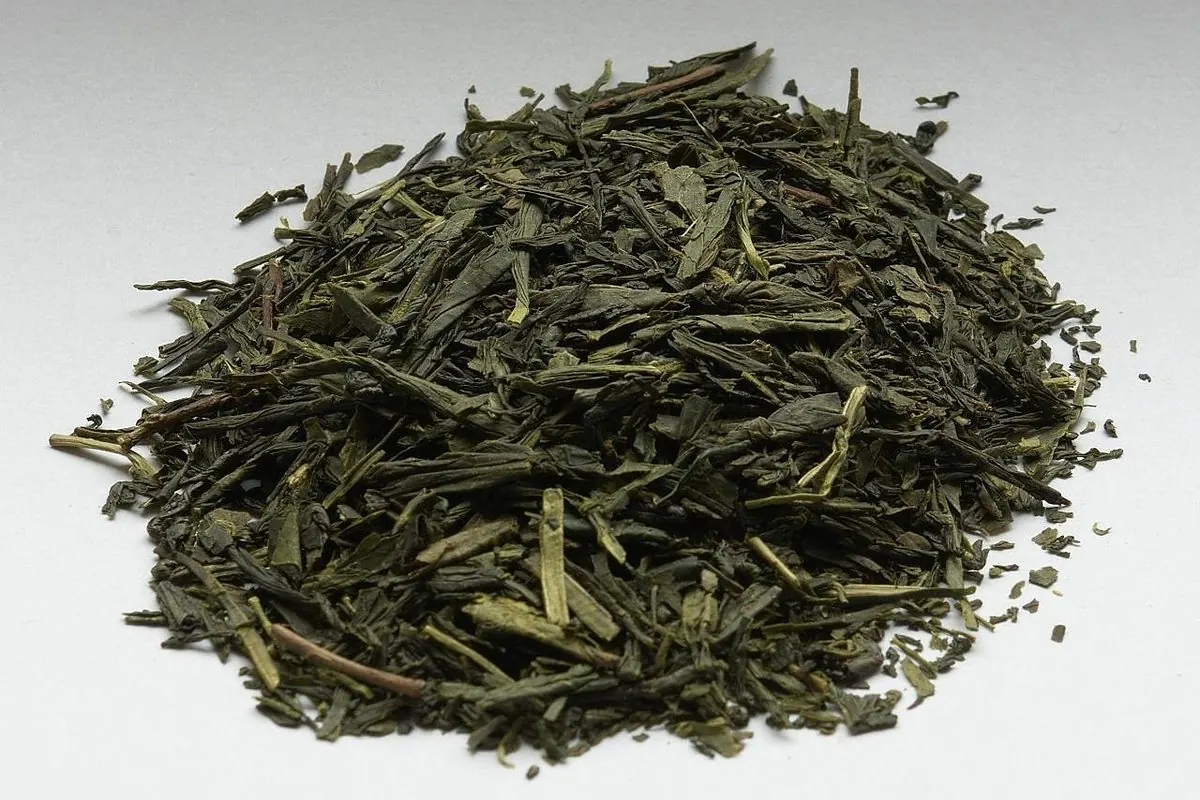 Đống lá chè xanh khô dạng sợi dẹt trên nền trắng