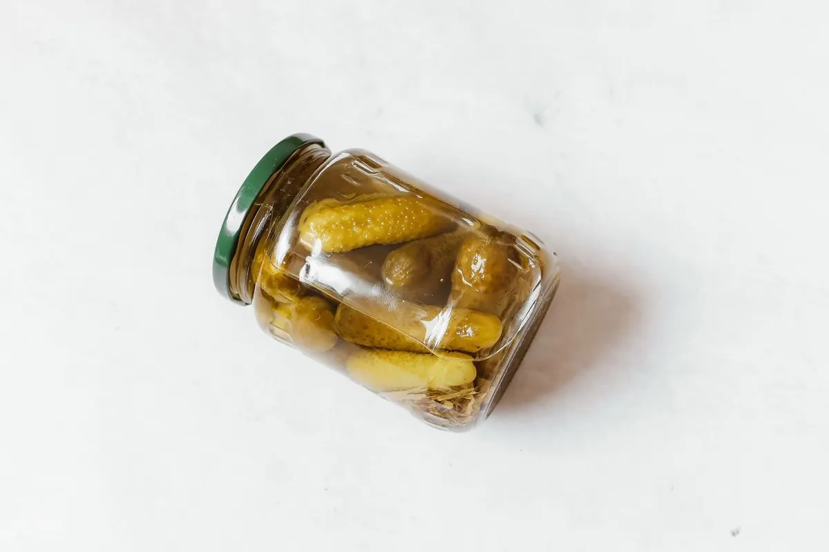 Jar of pickled gherkins on a white background