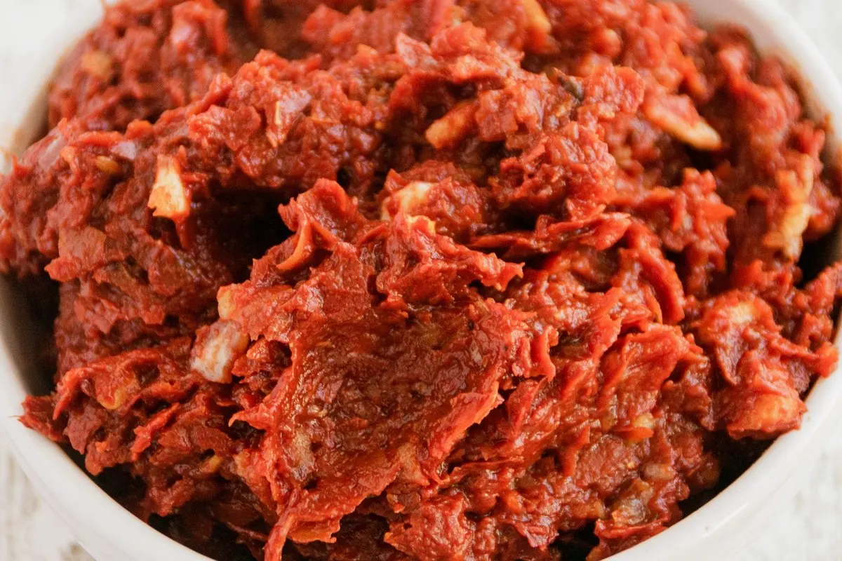 Dark red tomato paste in a white bowl