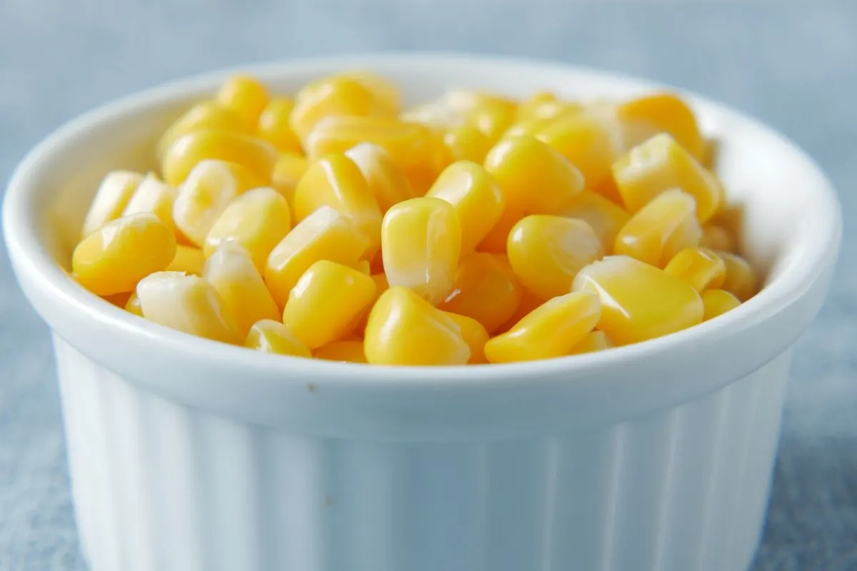 Prepared yellow sweet corn kernels in a white ramekin
