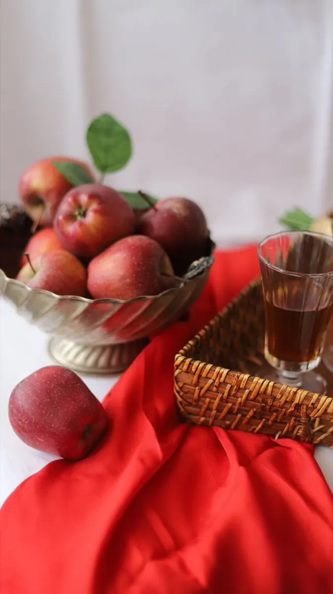Ly nước táo ép bên giỏ táo