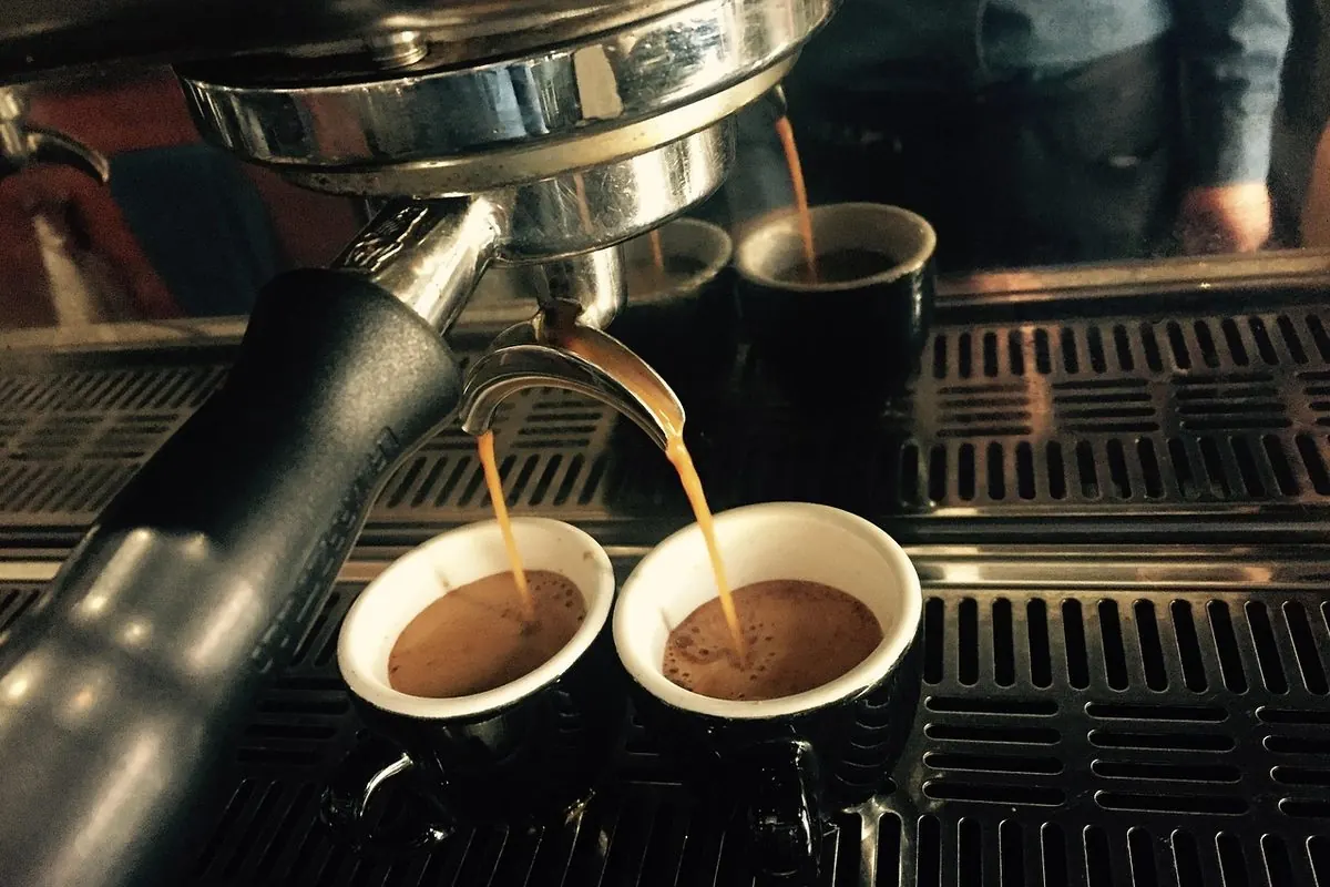 Máy pha espresso rót cà phê vào hai ly giấy