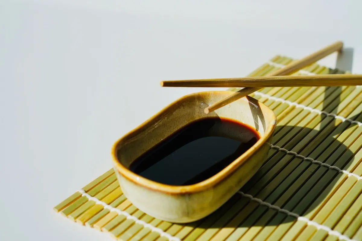 Chén nước tương với đôi đũa đặt trên mành tre