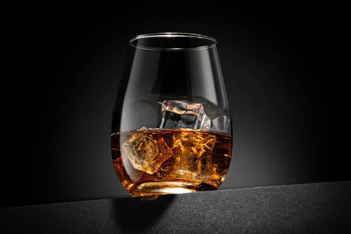 Ly rượu whisky có đá trên nền đen
