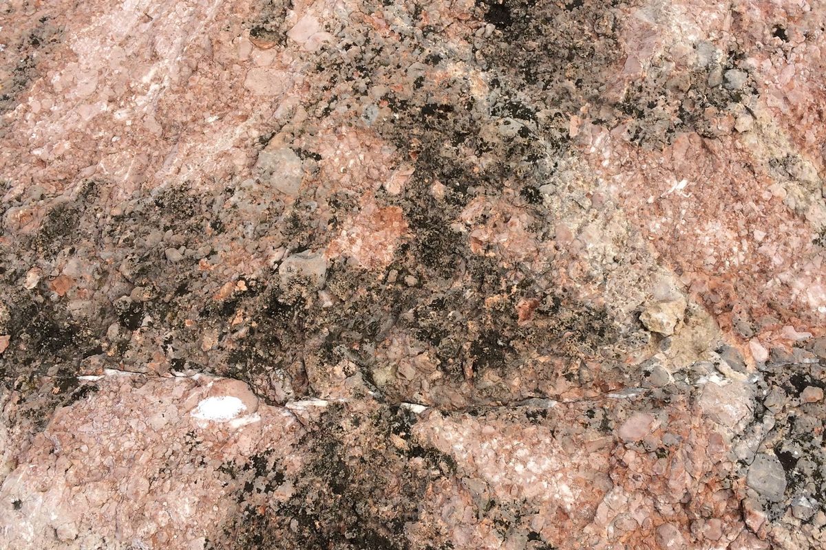Khối đá chứa tràng thạch màu hồng nhạt, bề mặt thô