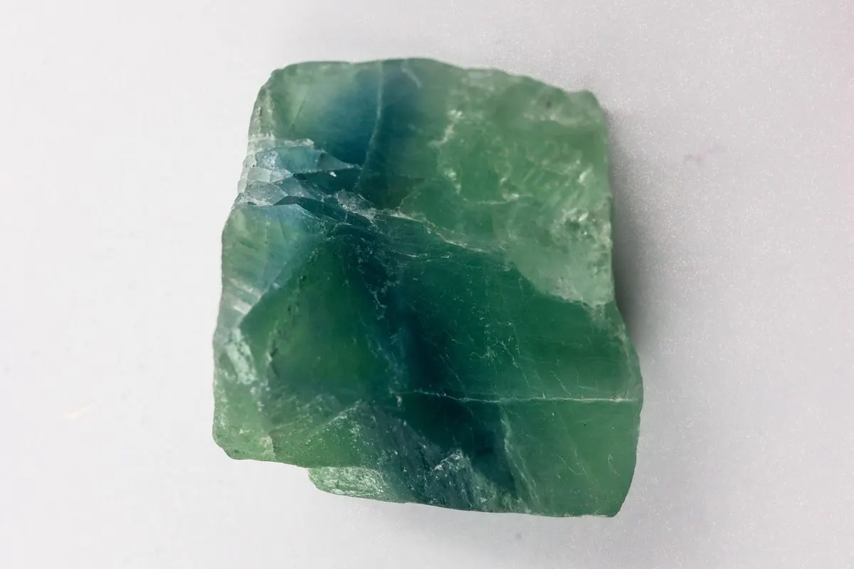 Cục khoáng fluorite thô màu xanh lục trên nền trắng