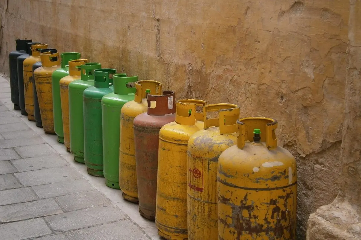 Hàng bình gas vàng và xanh xếp dọc bức tường