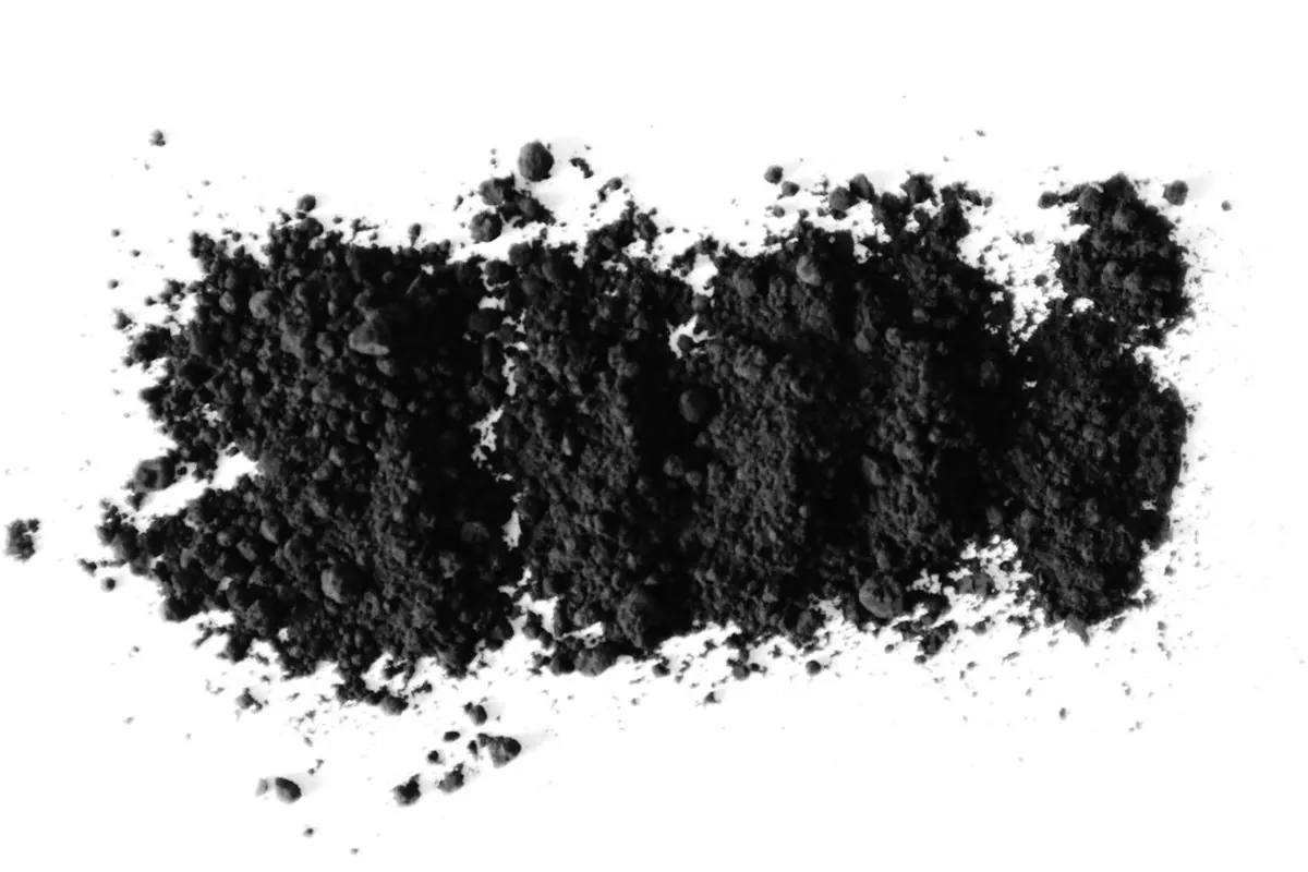Đống bột carbon đen mịn rải trên nền trắng