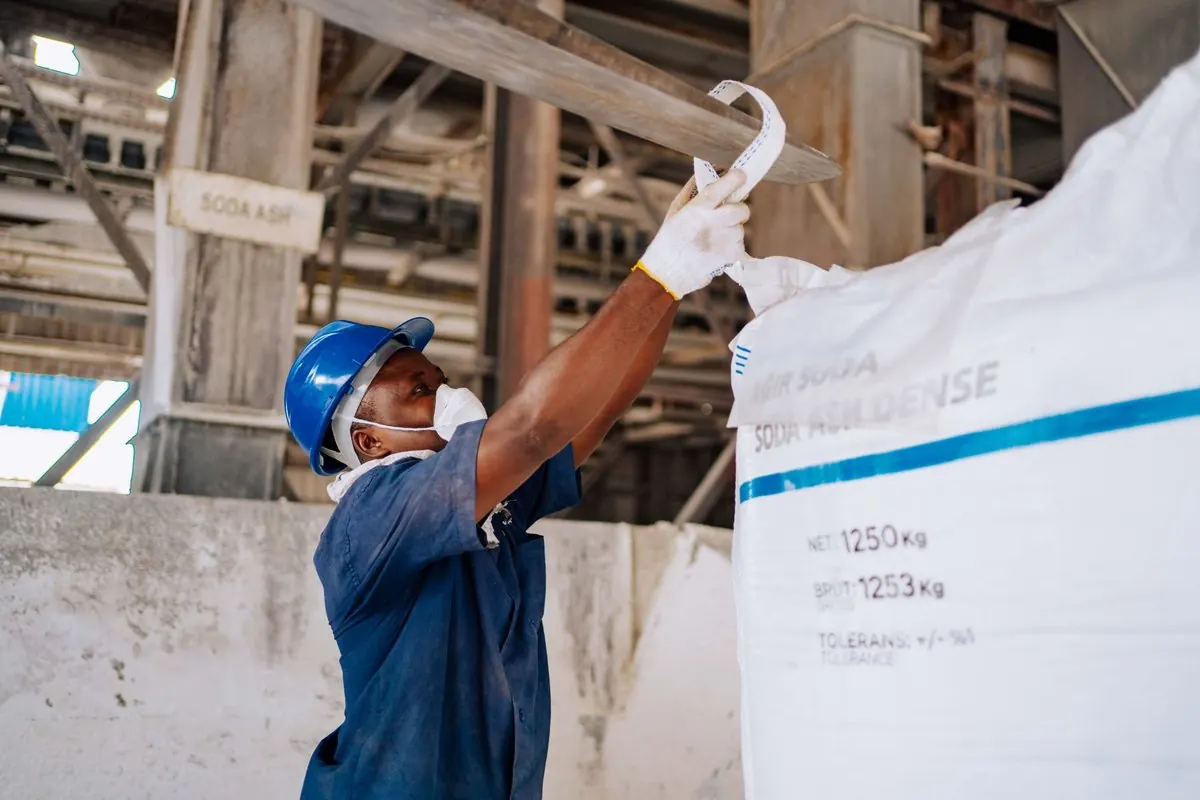 Công nhân đội mũ bảo hộ kiểm tra bao jumbo soda ash trong nhà máy