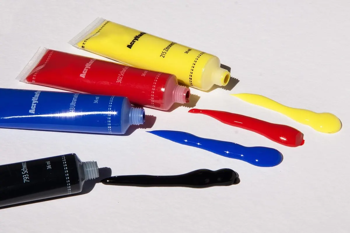 Các tuýp sơn acrylic nhiều màu và vệt sơn trên nền trắng