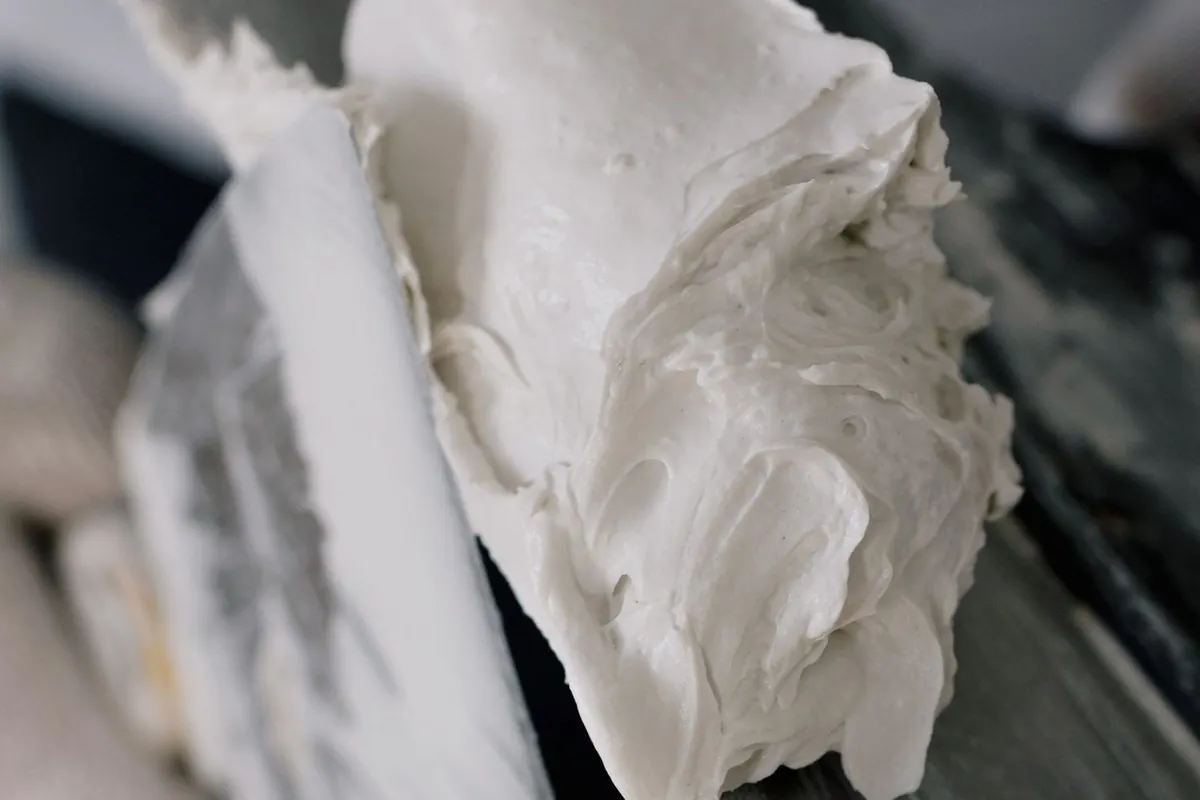 White putty filler being worked on a steel putty knife