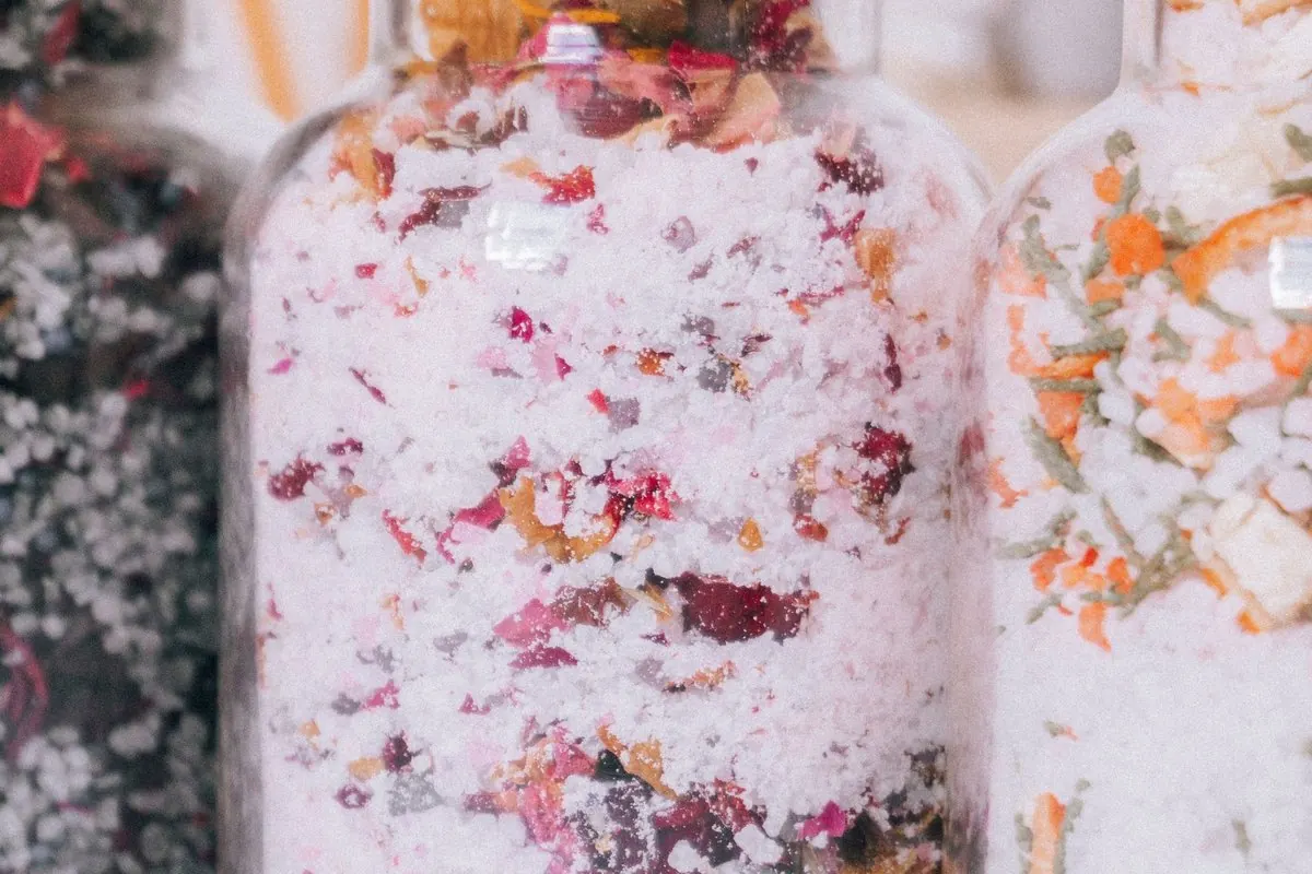 Glass jars of bath salts mixed with dried flower petals