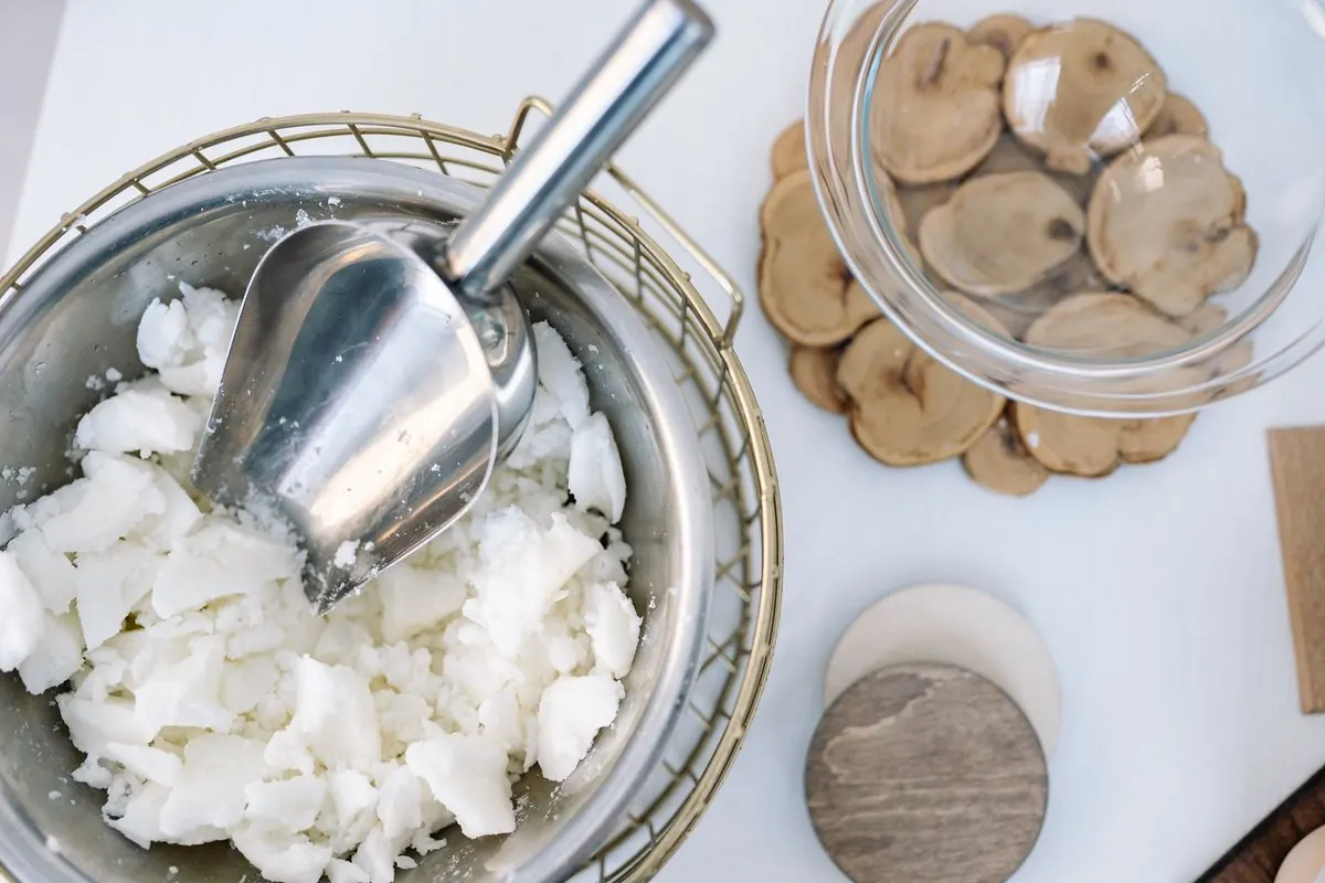 White wax flakes in a steel bowl with a scoop