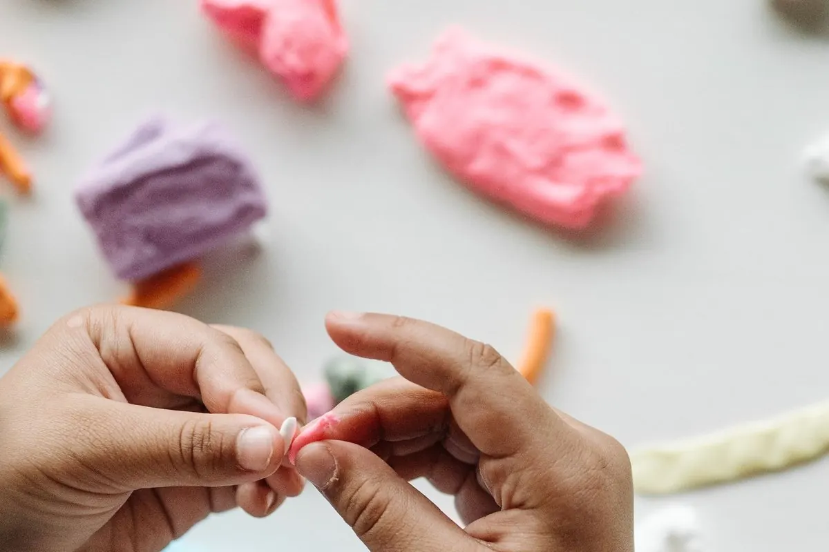 Child hands shaping coloured modelling clay
