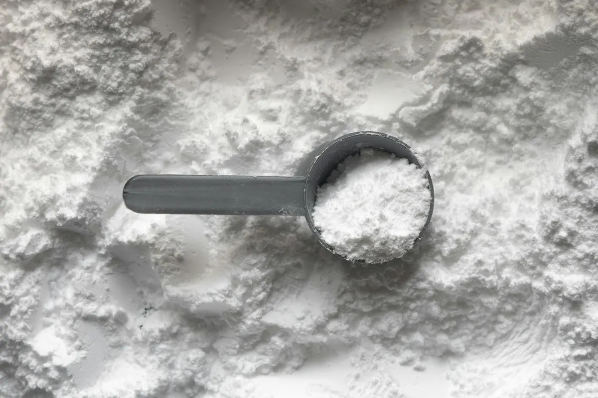 Bột protein màu trắng và muỗng đong nhựa