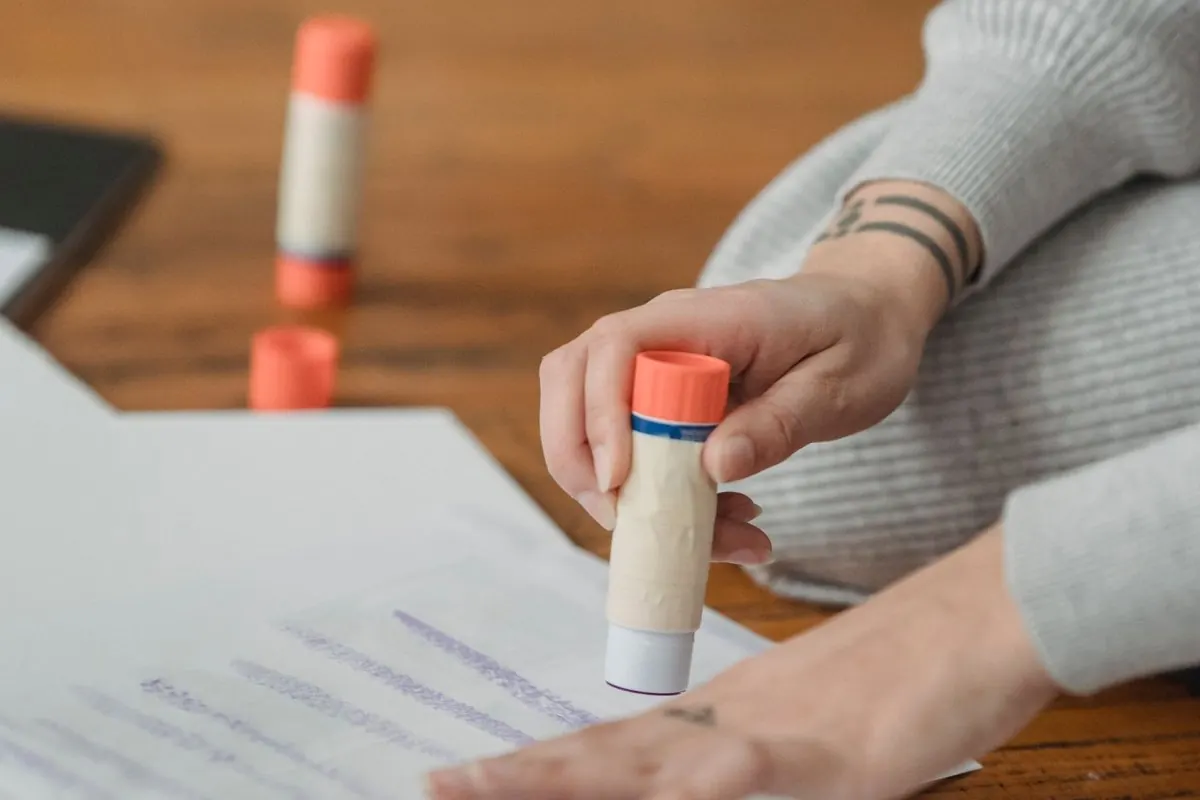 Person using a glue stick on paper