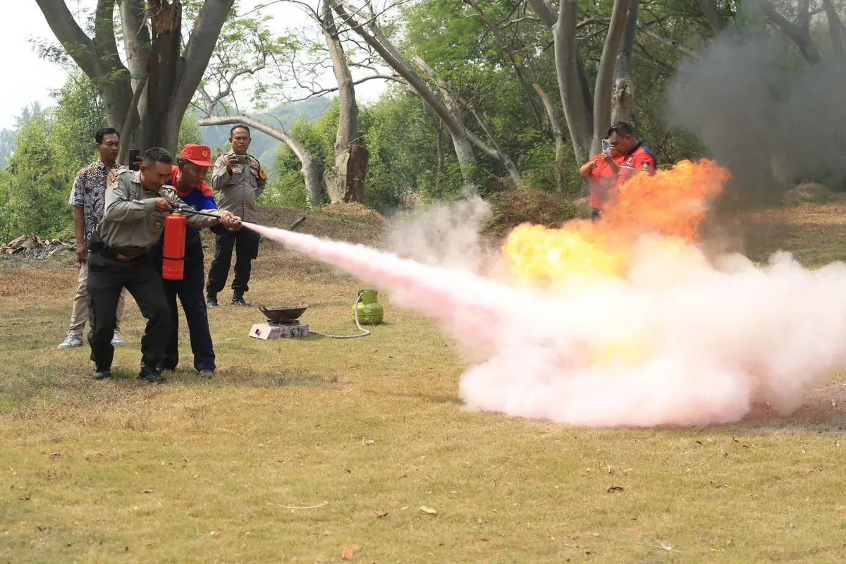 Fire extinguisher discharging a cloud of extinguishing powder during a drill