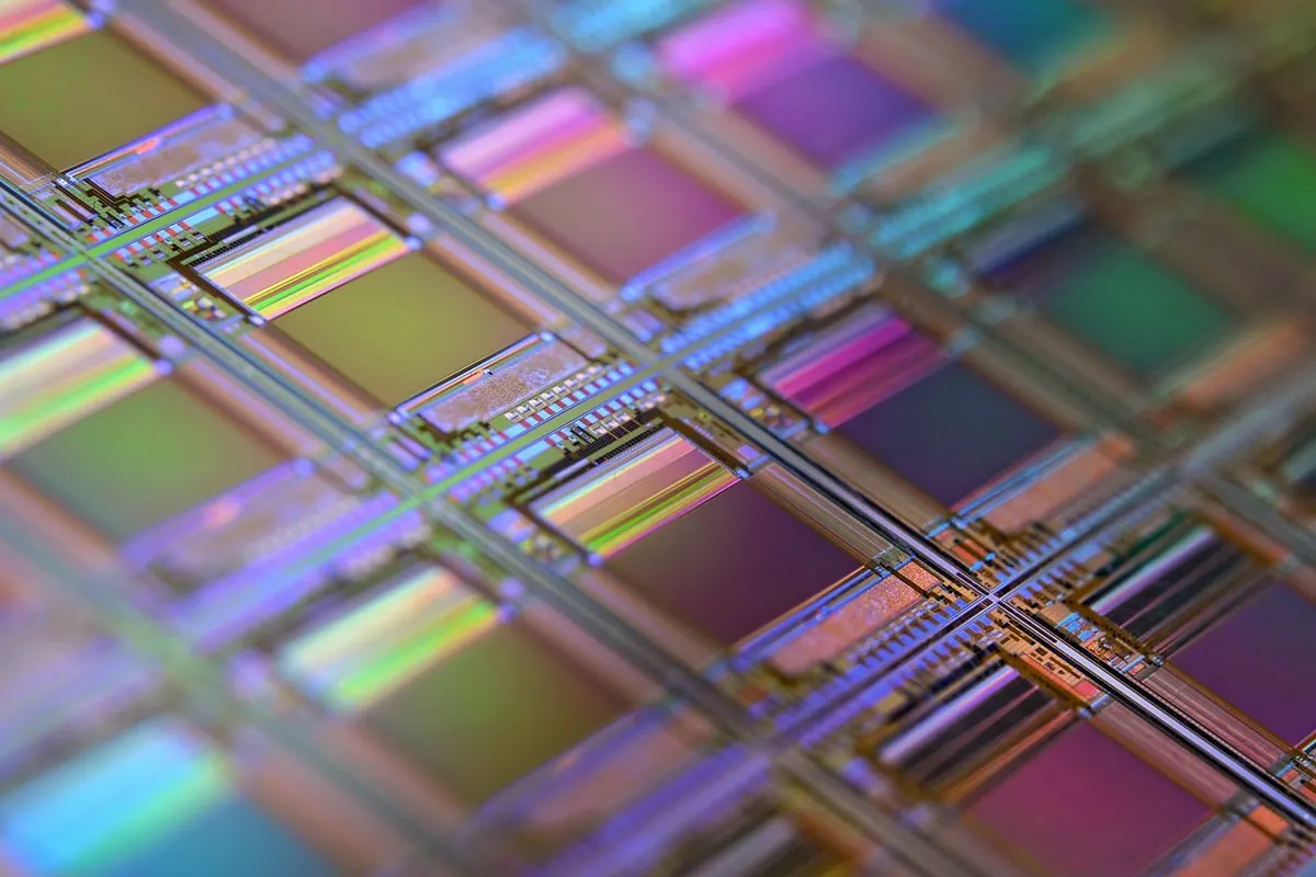 Close-up of a silicon wafer with a grid of iridescent chip dies