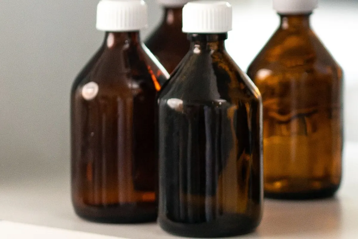 Three brown glass reagent bottles on a laboratory shelf