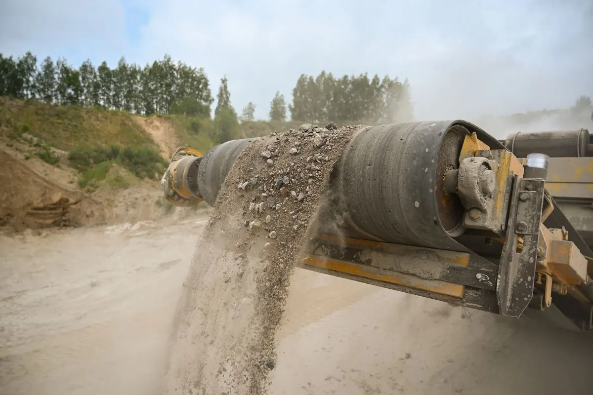 Rubber conveyor belt carrying gravel and sand at a quarry site