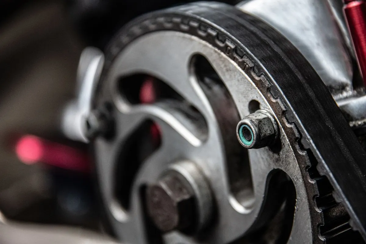 Black rubber timing belt running on a metal toothed pulley