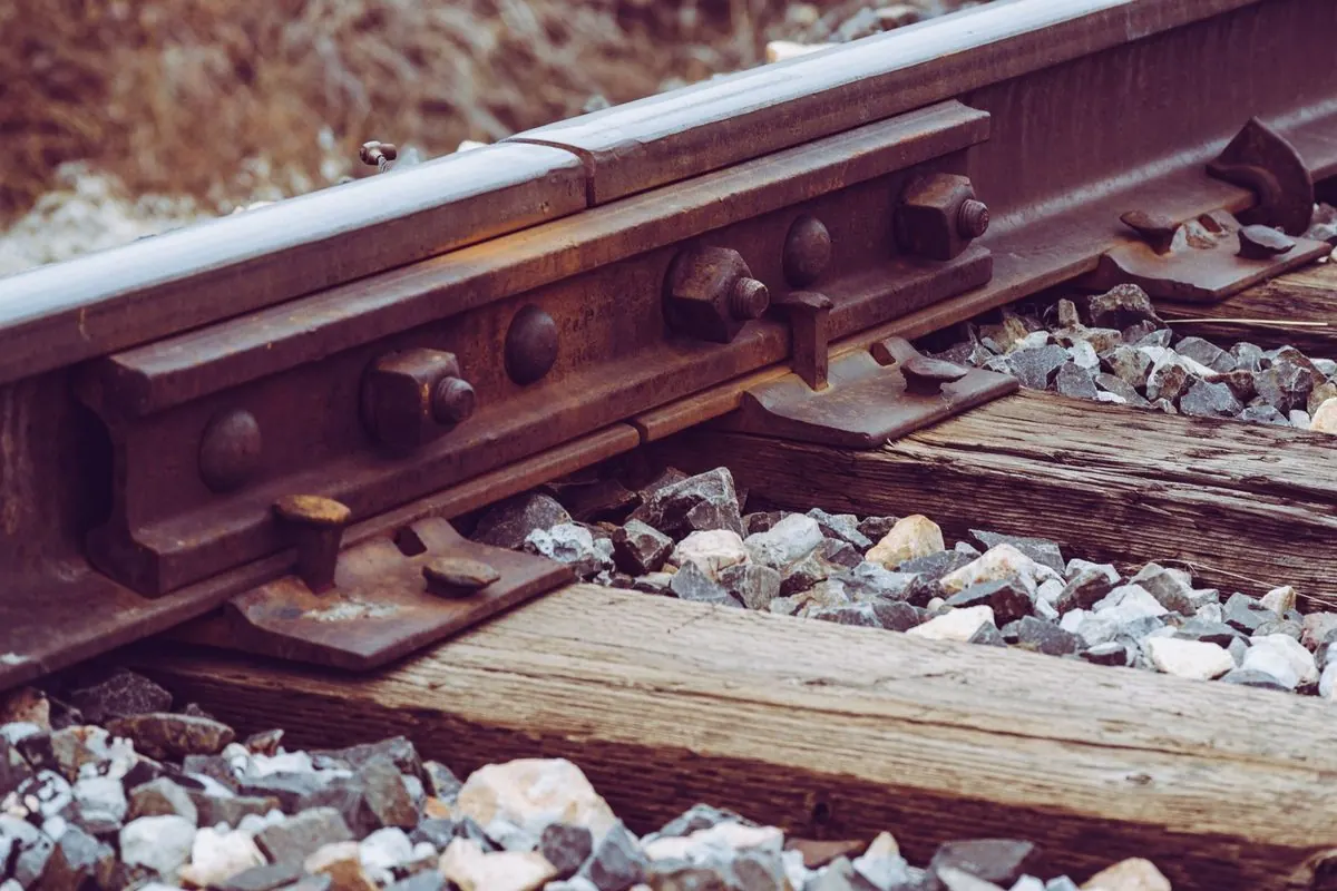 Wooden railway sleeper under the rail on gravel ballast