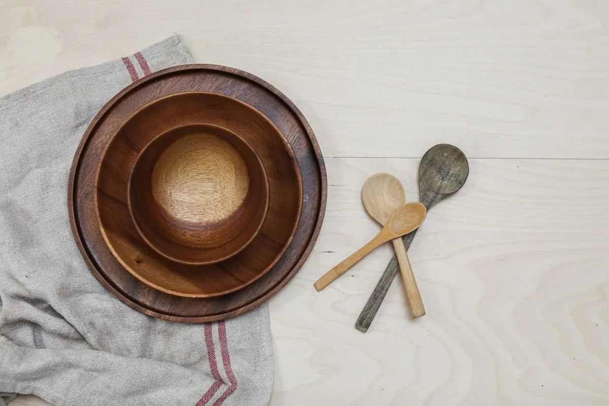 Wooden bowls and spoons on a cloth on a light table