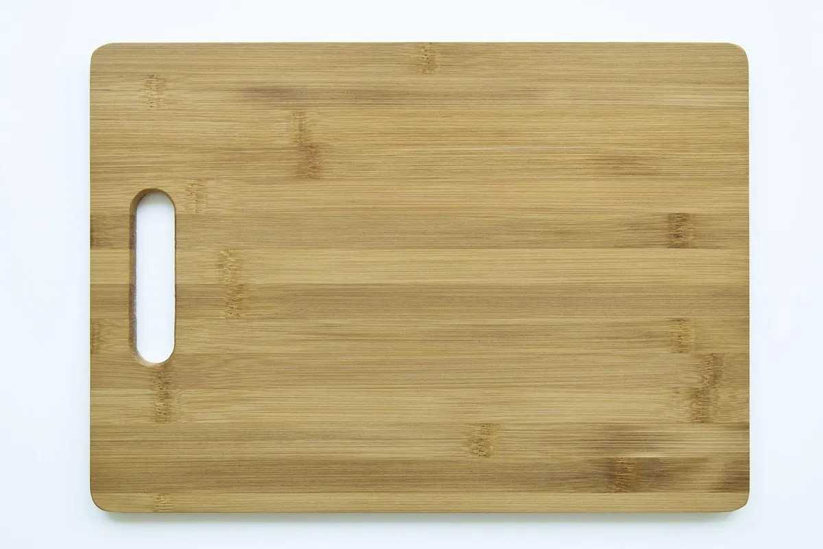 Rectangular bamboo cutting board with a handle hole on a light background