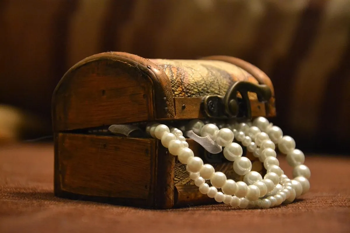 Small open wooden box with a pearl necklace inside