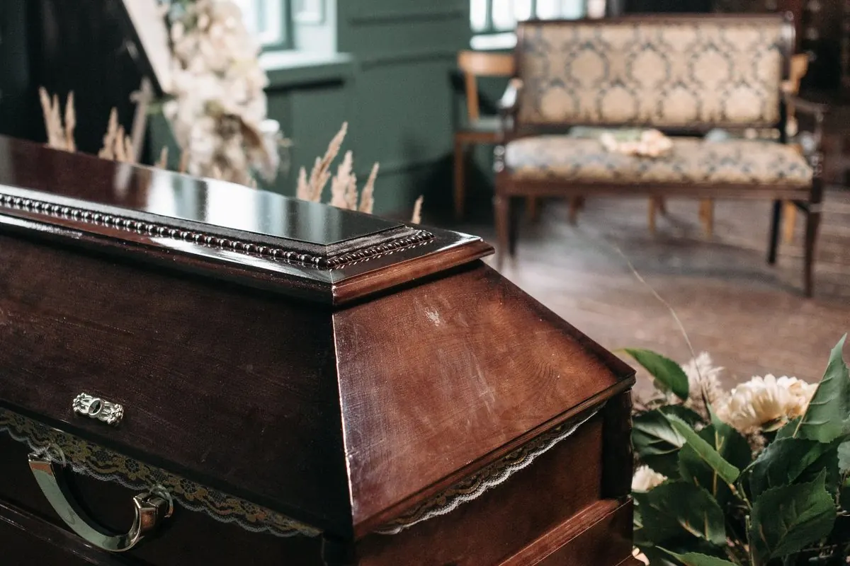 Glossy brown wooden coffin in a funeral room