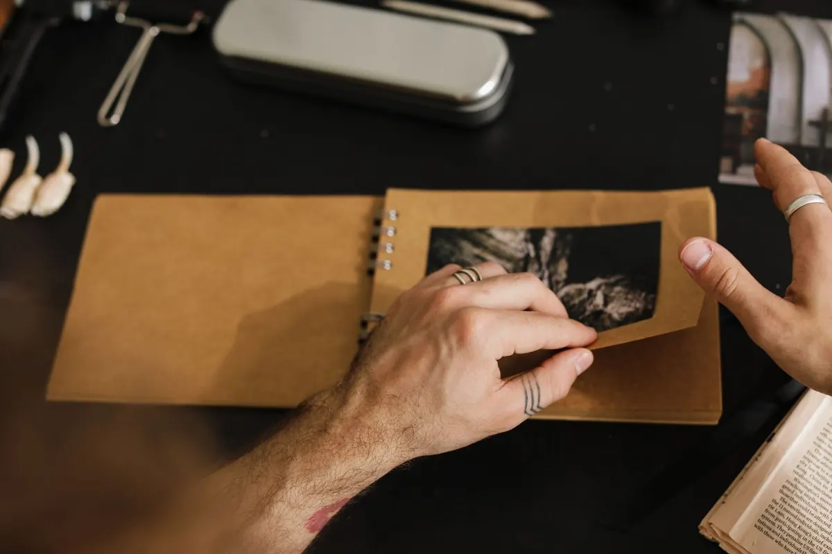 Hands turning a page of a spiral-bound kraft paper photo album
