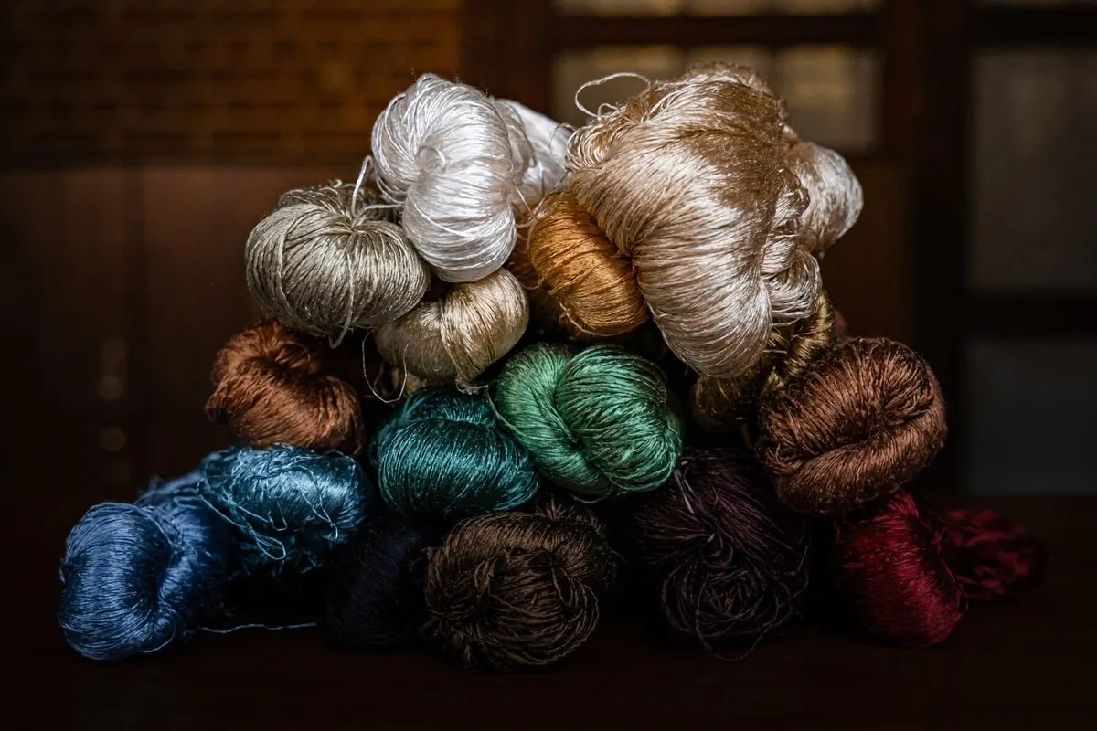 Hanks of silk yarn in many dyed colours piled together