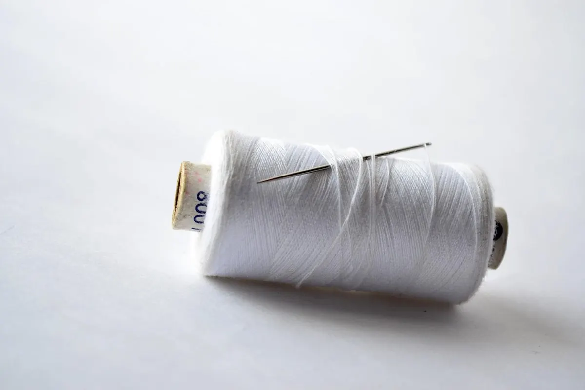 Một ống sợi cotton trắng cắm kim