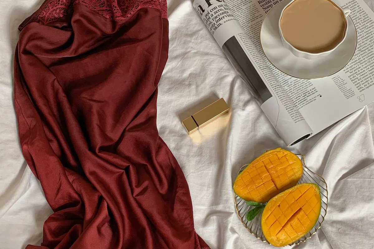 Váy ngủ lụa satin đỏ trải trên ga trắng