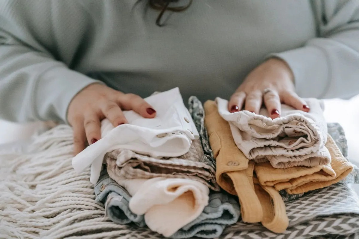 Chồng quần áo trẻ em gấp gọn nhiều màu be và nâu