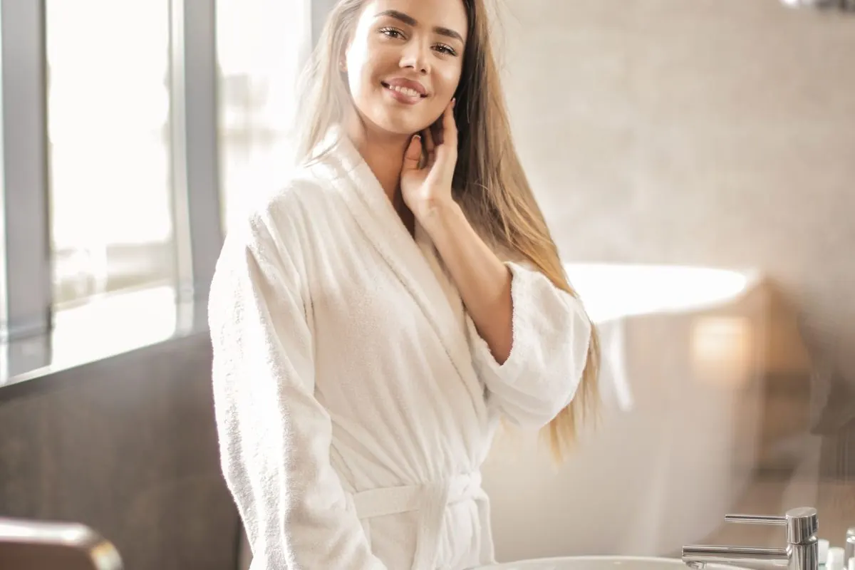 Người phụ nữ mặc áo choàng tắm trắng trong phòng tắm