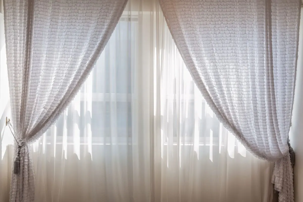 Rèm cửa trắng buông hai bên cửa sổ
