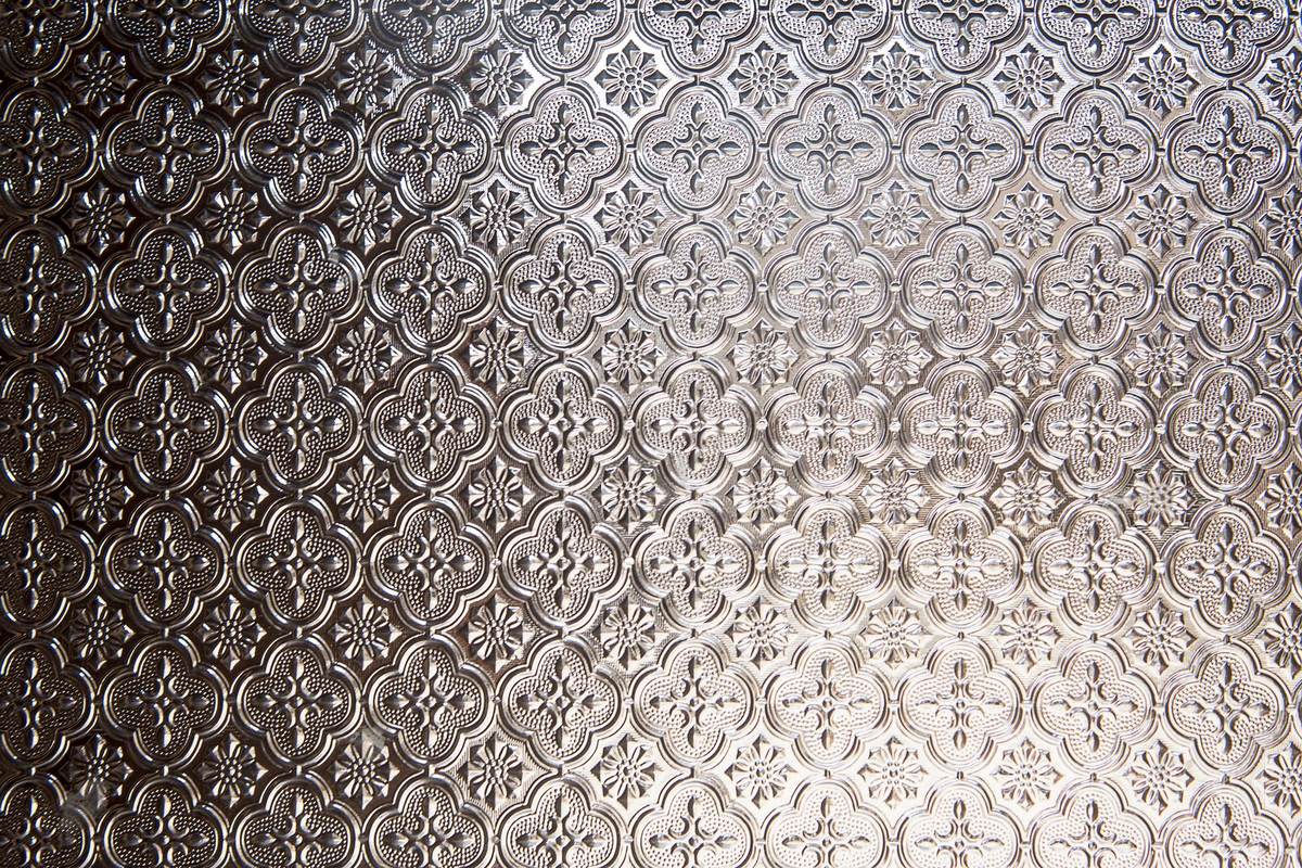 Close-up of patterned rolled glass with a raised motif