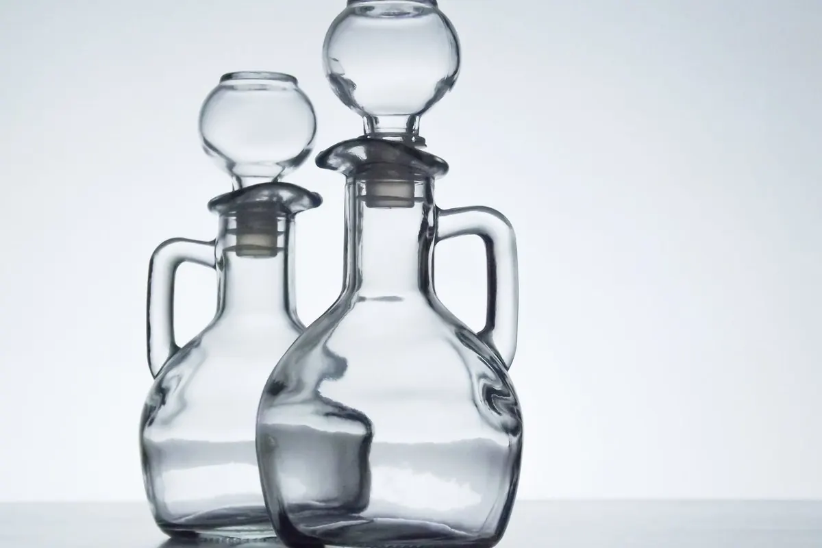 Two glass cruets closed with glass stoppers on a white background