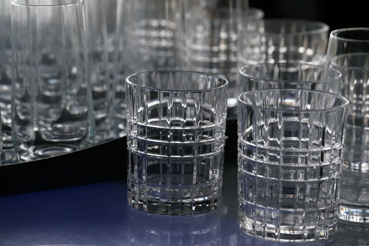 Rows of cut-pattern drinking glasses on a tray