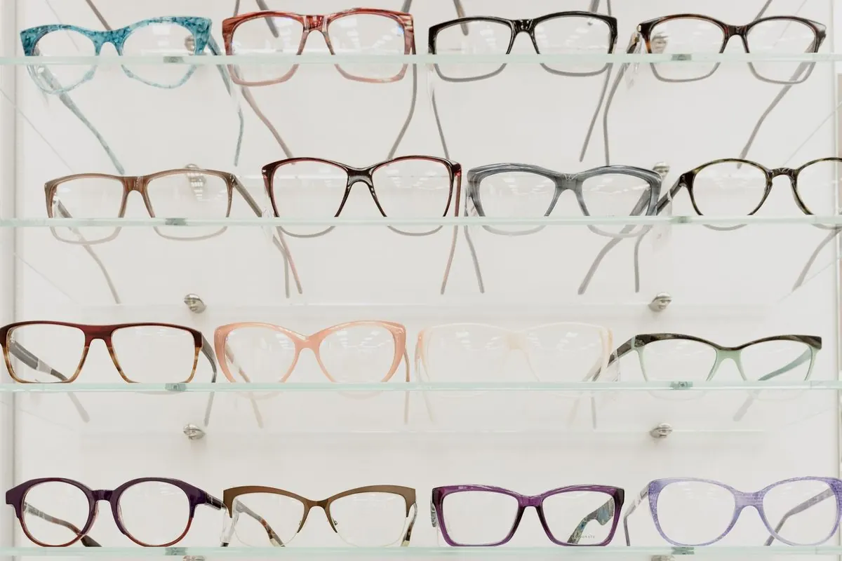 Many eyeglass frames arranged on clear shelves