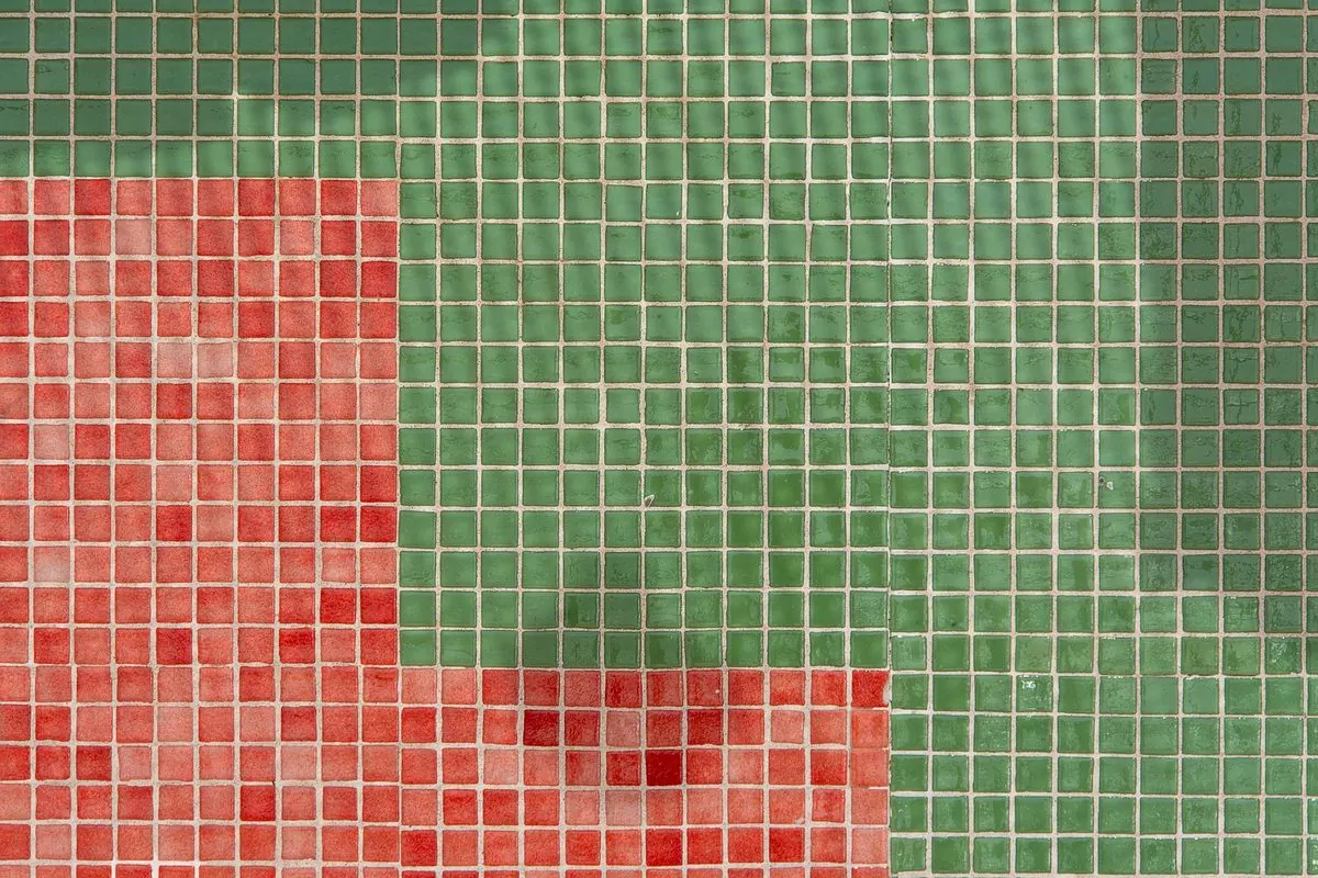 Small square green and red mosaic tiles laid in a panel
