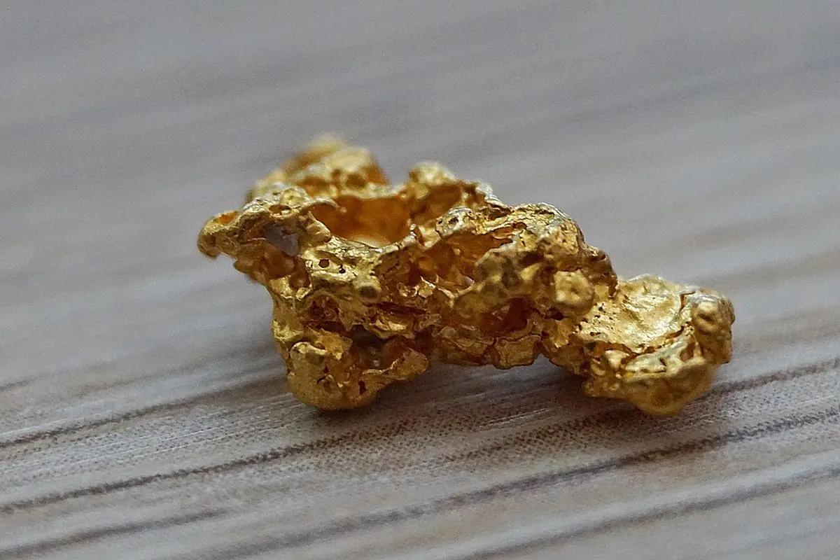 Cục vàng tự nhiên đặt trên mặt gỗ xám
