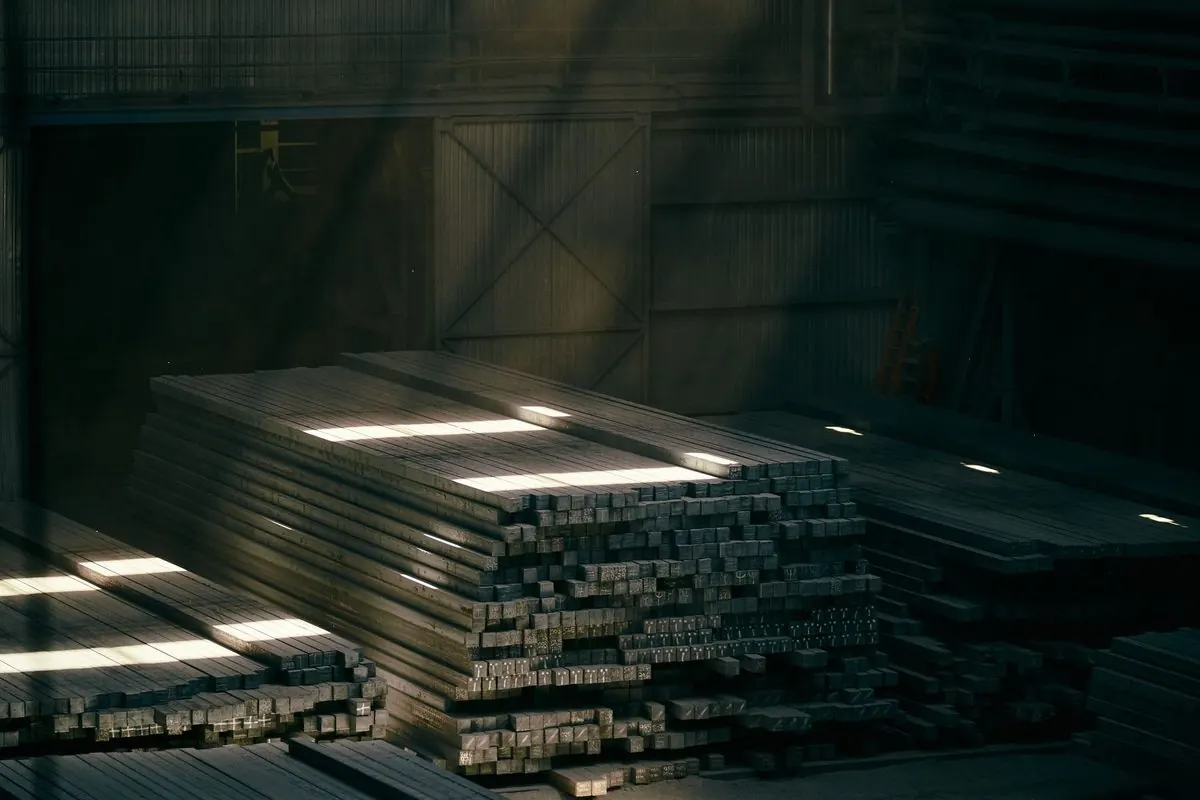 Stacks of flat steel bars in a warehouse